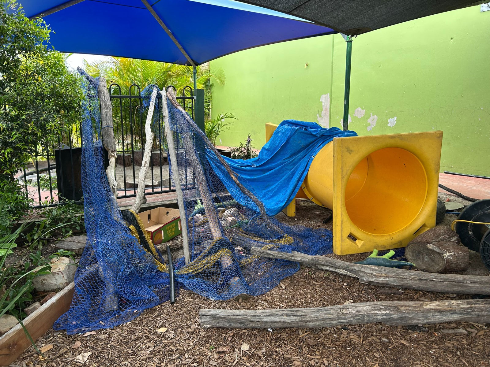 A photograph of an outdoor play area made of structures built by children from loose parts